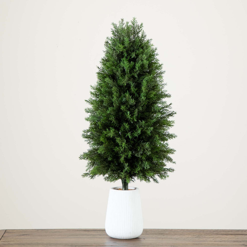Lifestyle image showing the tree in a decorative setting with planter.