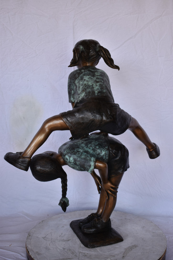 Two Girls Playing Leapfrog Jumping Bronze Statue Size: 30"L x 14"W x 34"H.