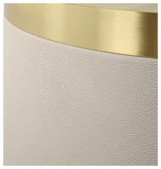 Close-up of leather texture and gold rim on white background.