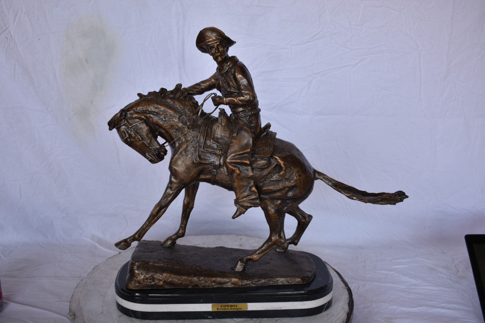 Remington Cowboy Replica Bronze Statue on Triple Marble Size: 8"x 26"x 23"H.