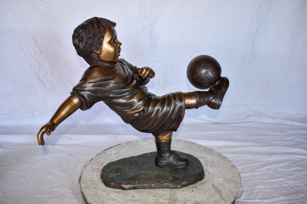 Young Boy Passionately Kicking Soccer Ball Bronze Statue  Size: 26" x 16" x 24