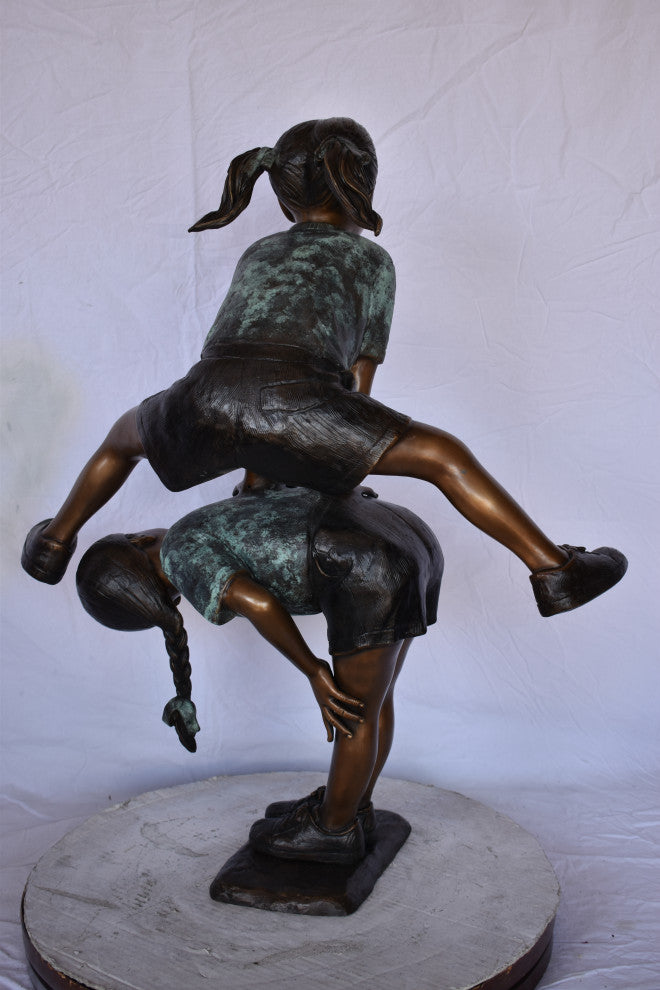 Two Girls Playing Leapfrog Jumping Bronze Statue Size: 30"L x 14"W x 34"H.
