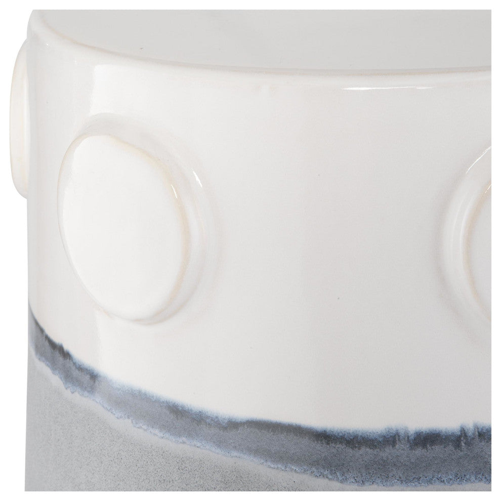 Close-up detail of side with circular raised motifs and glaze line on white ceramic against white background.