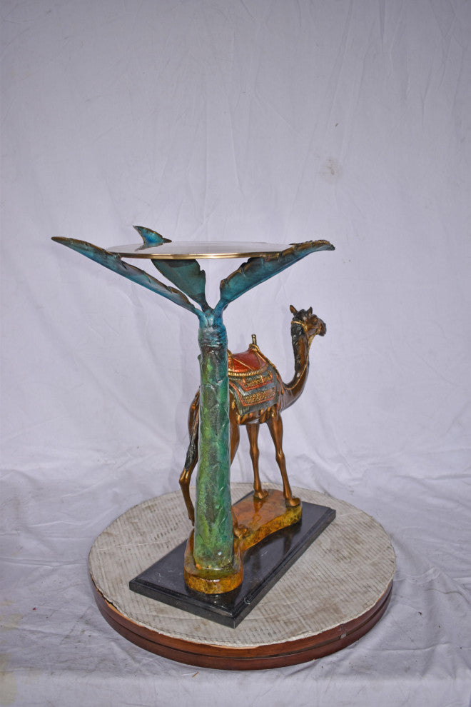 Camel Standing Under A Palm Tree Bronze Statue - Size: 20"L x 29"W x 25"H.