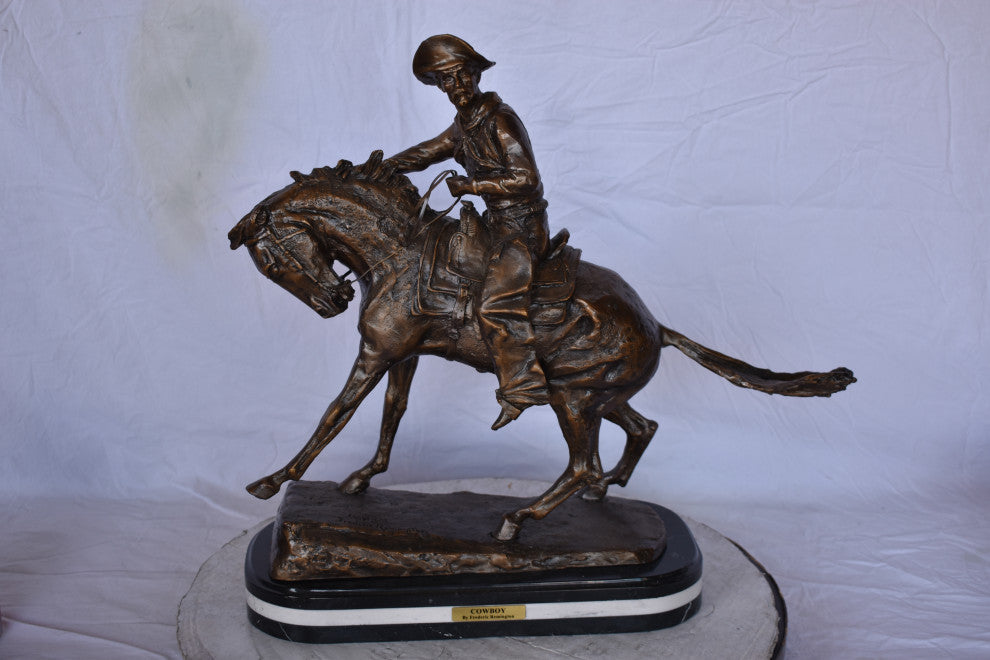 Remington Cowboy Replica Bronze Statue on Triple Marble Size: 8"x 26"x 23"H.