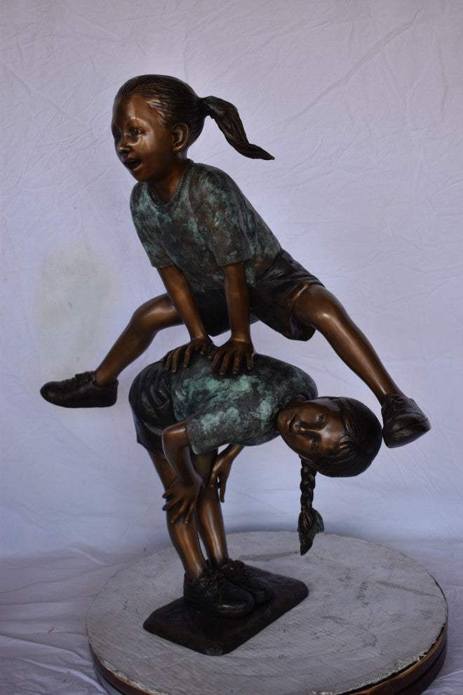 Two Girls Playing Leapfrog Jumping Bronze Statue Size: 30"L x 14"W x 34"H.