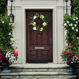 Wreath shown in a real outdoor/entry environment with door and planters; lifestyle context.