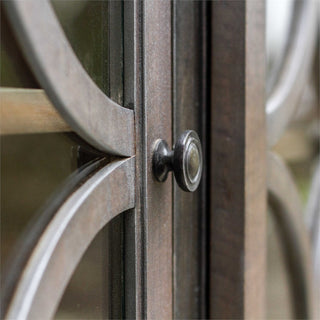 Close-up of cabinet detail (door glass/lattice and knob) with lifestyle background; cropped view of a feature.
