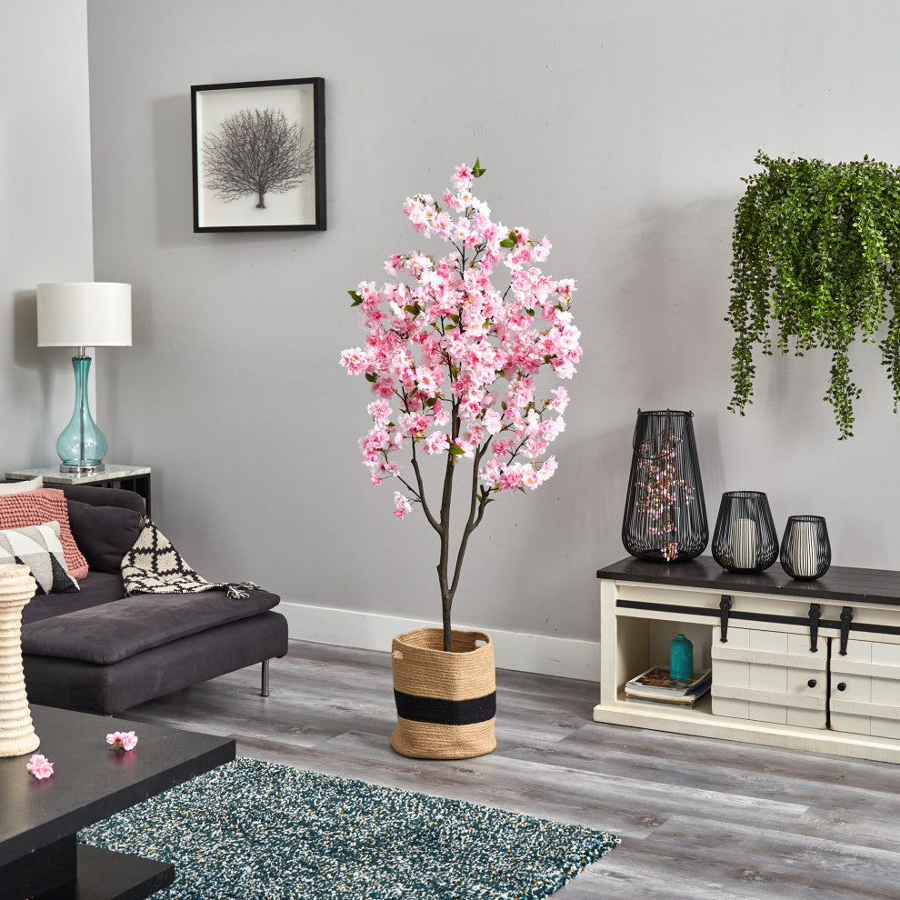 Lifestyle image: cherry blossom tree shown in a living room environment with decor; product is fully visible.