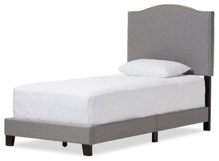 Full front-facing/dominant view of the bed showcasing the arched headboard and gray fabric.