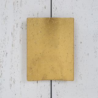 Close-up of gold handle on white background.