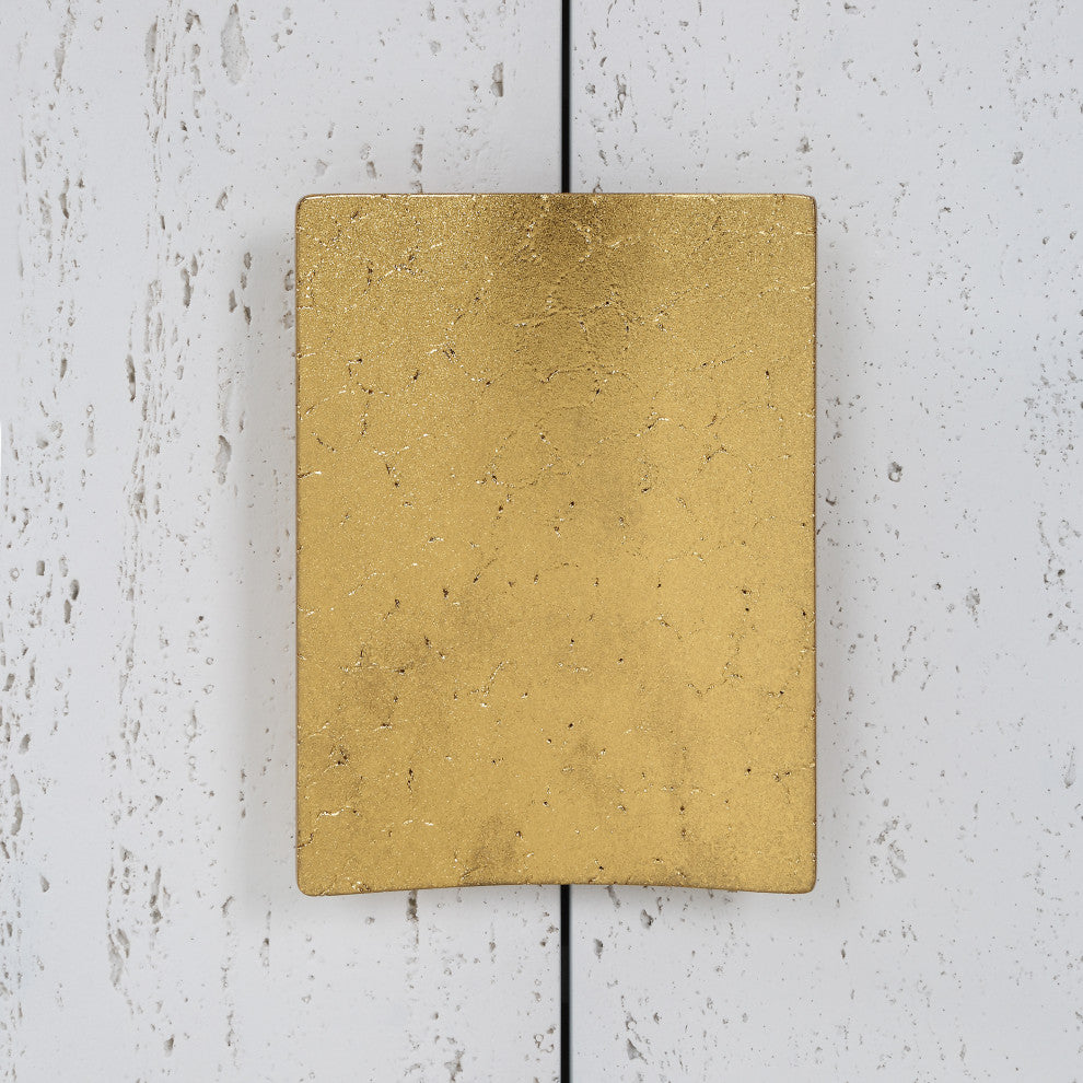 Close-up of gold handle on white background.