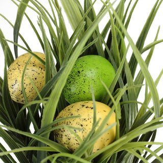 Close-up on white background focusing on the grass and eggs.
