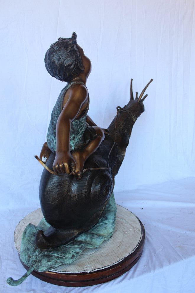 Happy boy riding a snail bronze statue fountain -  Size: 42"L x 14"W x 34"H.