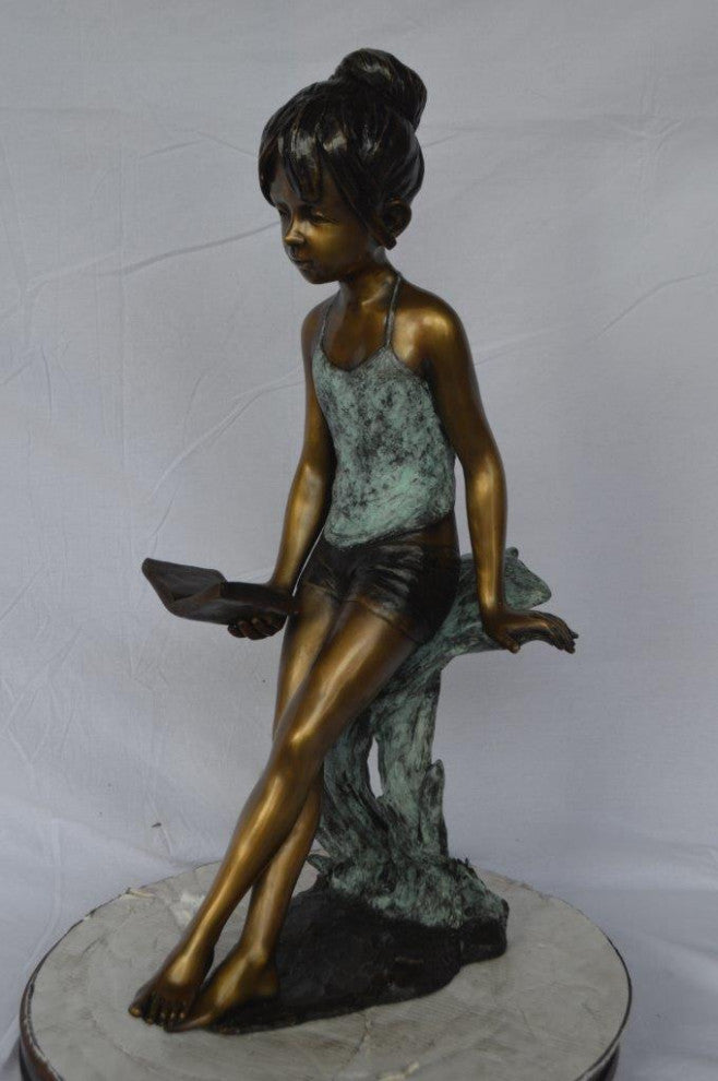 Girl sitting and reading a book bronze statue -  Size: 19"L x 15"W x 36"H.