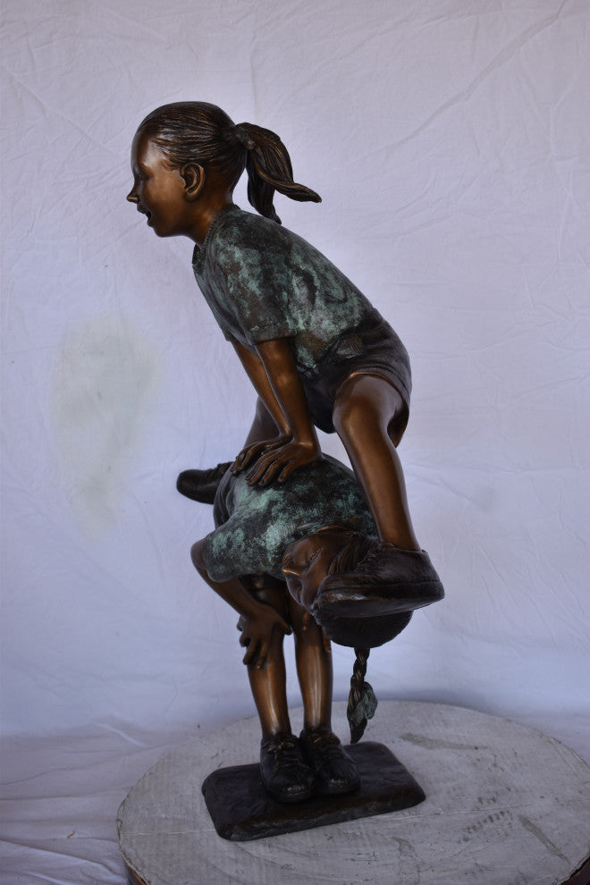 Two Girls Playing Leapfrog Jumping Bronze Statue Size: 30"L x 14"W x 34"H.