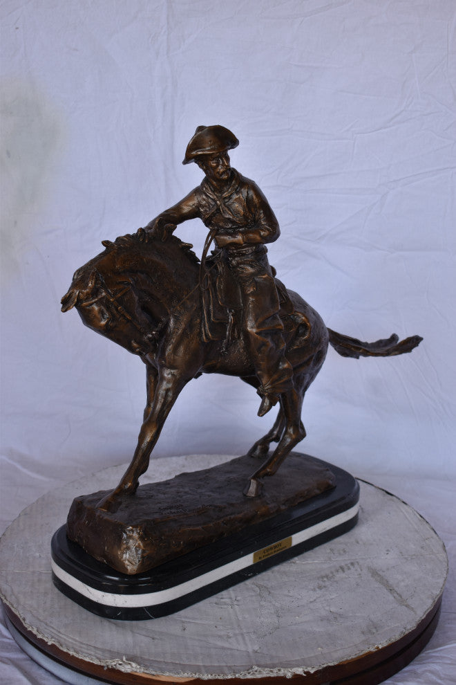 Remington Cowboy Replica Bronze Statue on Triple Marble Size: 8"x 26"x 23"H.