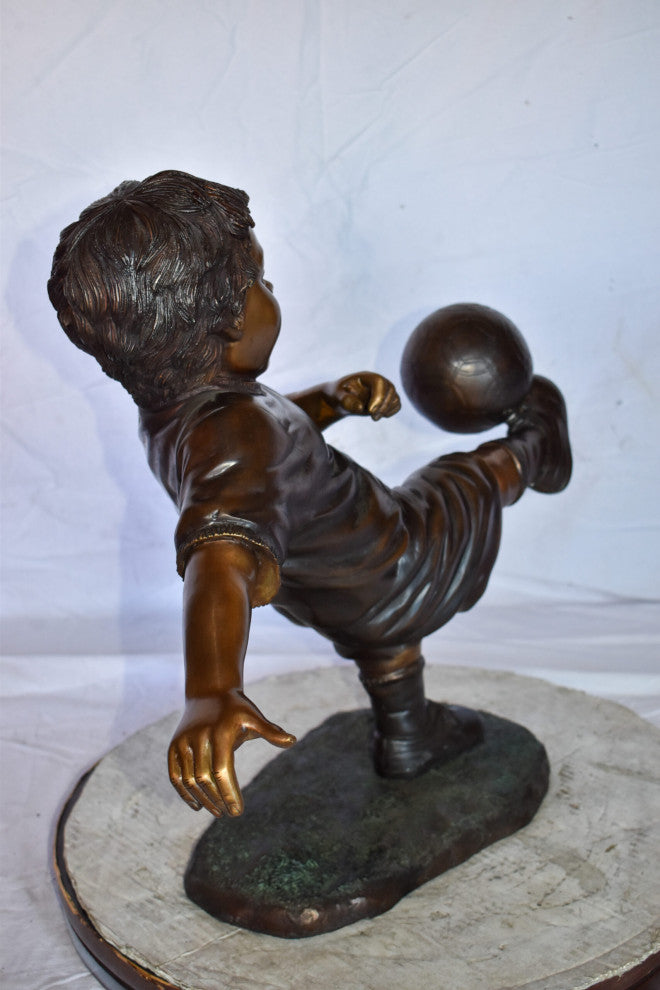 Young Boy Passionately Kicking Soccer Ball Bronze Statue  Size: 26" x 16" x 24