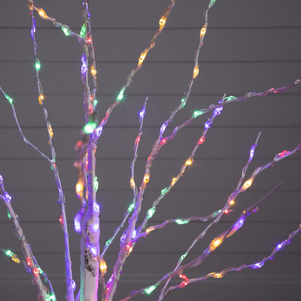 Close-up of LED wires on branches against a dark background.