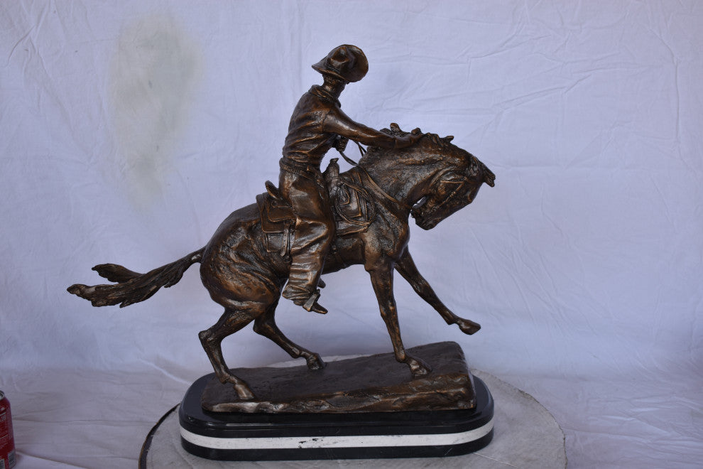 Remington Cowboy Replica Bronze Statue on Triple Marble Size: 8"x 26"x 23"H.