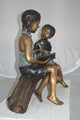 Boy and Girl on a tree log reading Bronze Statue -  Size: 37"L x 14"W x 27"H.