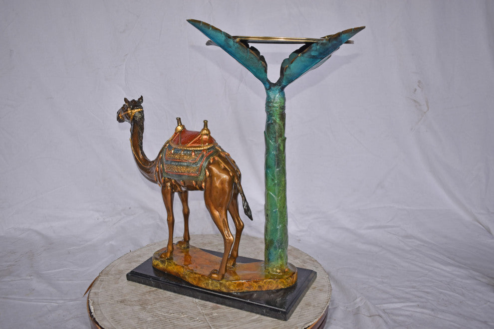 Camel Standing Under A Palm Tree Bronze Statue - Size: 20"L x 29"W x 25"H.