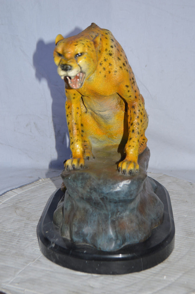 Cheetah sitting on a rock growling bronze statue - Size: 18"L x 12"W x 18"H.