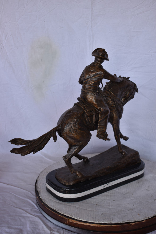 Remington Cowboy Replica Bronze Statue on Triple Marble Size: 8"x 26"x 23"H.