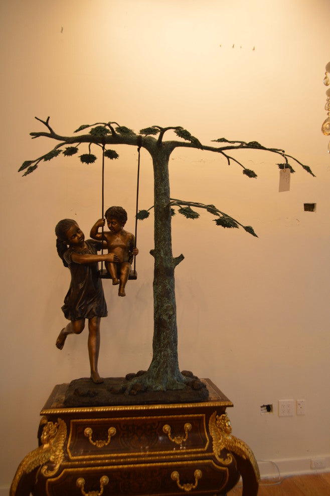 Swing Set Under A Three Bronze Statue -  Size: 60"L x 33"W x 60"H.