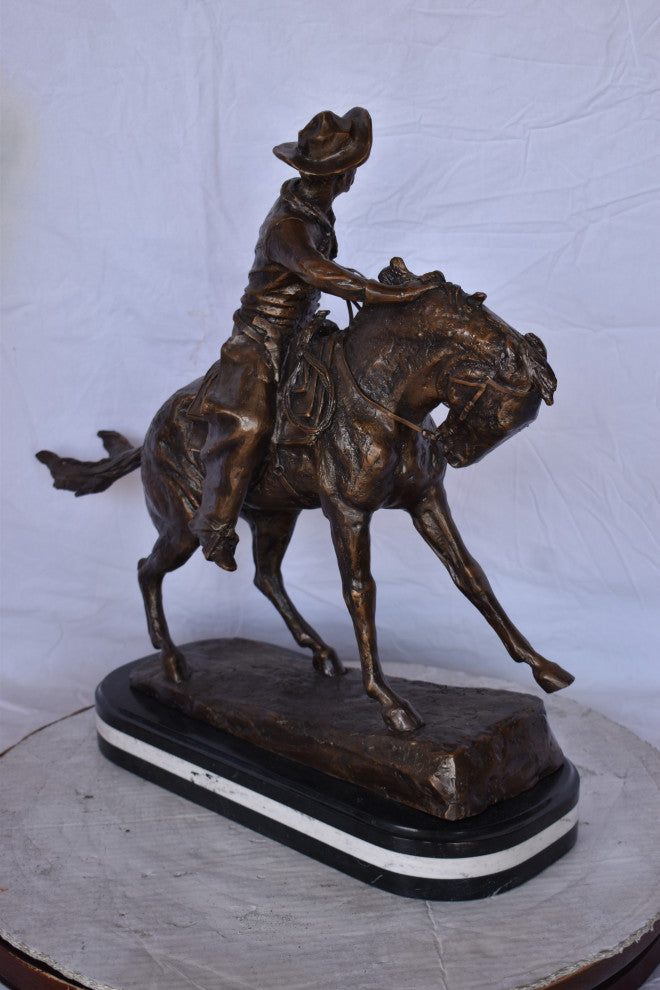 Remington Cowboy Replica Bronze Statue on Triple Marble Size: 8"x 26"x 23"H.