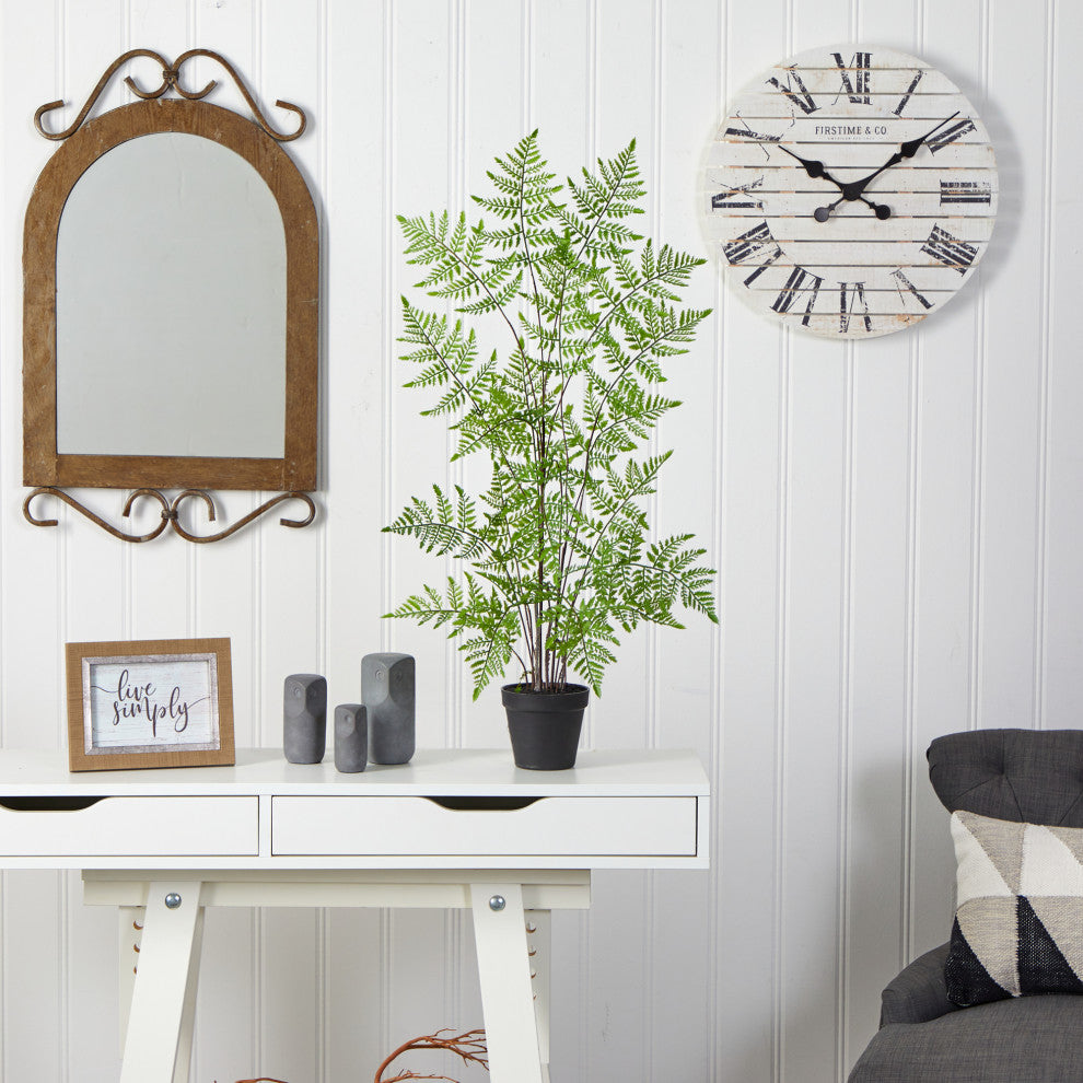 Lifestyle image with fern placed on a white desk in a styled room; no text overlaid; entire plant visible.