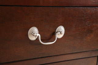 Close-up of drawer handle on wood surface.